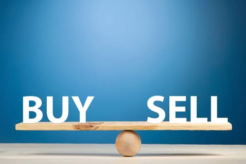 The words buy and sell are balanced on a seesaw.