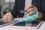 Business analyst reviews revenue expenses profit on tablet in office for financial report forecast strategy growth trend KPI data analytics dashboard investment performance ROI budgeting