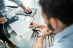 Close-up of male customer signing contract.